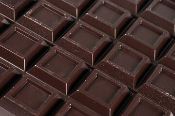 Close up a chocolate bar background. Chocolate bar cubes macro