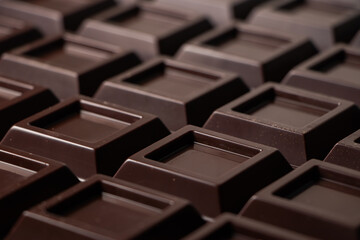 Close up a chocolate bar background. Chocolate bar cubes macro