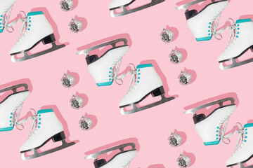 Winter creative pattern made with retro skates and disco ball decoration on pastel pink background....