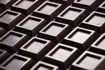 Close up a chocolate bar background. Chocolate bar cubes macro