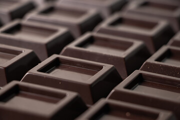 Close up a chocolate bar background. Chocolate bar cubes macro
