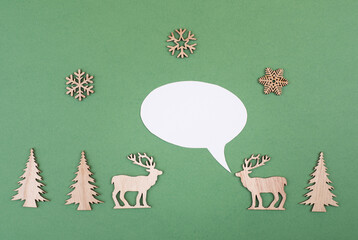 Two cute reindeers talking to each other, speech bubble with copy space, christmas greetings, green colored background