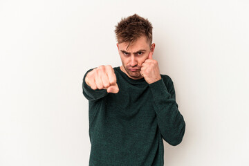 Young caucasian man isolated on white background throwing a punch, anger, fighting due to an argument, boxing.