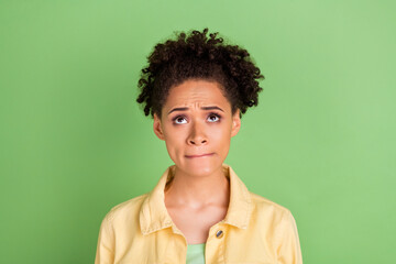 Fototapeta na wymiar Photo of worried millennial brunette lady look up wear yellow shirt isolated on green color background