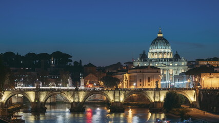 Fototapeta premium Vatican, Italy. Papal Basilica Of St. Peter In The Vatican And Aelian Bridge In Evening Night Illuminations. Day To NIght Time Lapse. Sunset Time