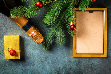 Christmas photo frame mock up template with decoration on dark background. View from above. New year mockup. New year composition with champagne bottle and decor. New year 2022