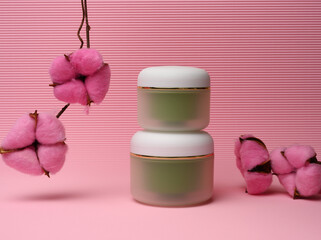 Obraz na płótnie Canvas green jar for cosmetics on a pink background. Packaging for cream, gel, serum, advertising and product promotion