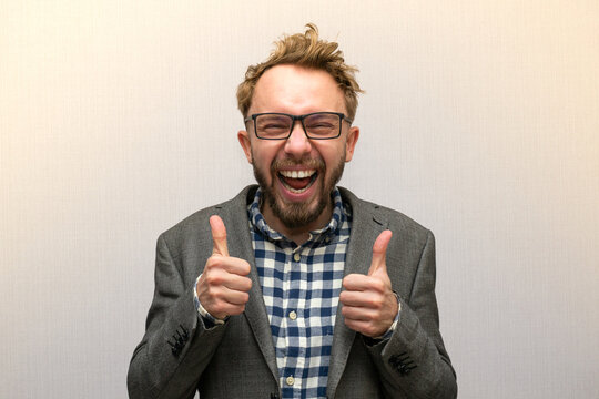 Happy Funny nerdy weirdo caucasian bearded man with eyeglasses in a suit cheering and showing thumbs up