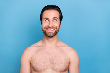 Photo of dreamy funny young guy shirtless smiling looking empty space isolated blue color background