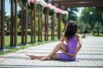 Naklejka premium young girl make yoga pose in the park, balance, fitness, stretching and relaxation 