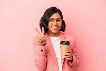 Young latin woman holding take away coffee isolated on pink background showing number two with fingers.