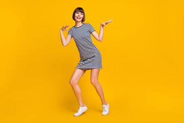 Fototapeta na wymiar Full size photo of funny brunette millennial lady dance wear striped dress isolated on yellow background