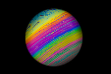 Abstract multicolor psychedelic planet. Closeup Soap bubble like an alien planet on dark background