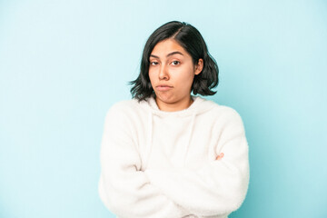 Fototapeta premium Young latin woman isolated on blue background unhappy looking in camera with sarcastic expression.