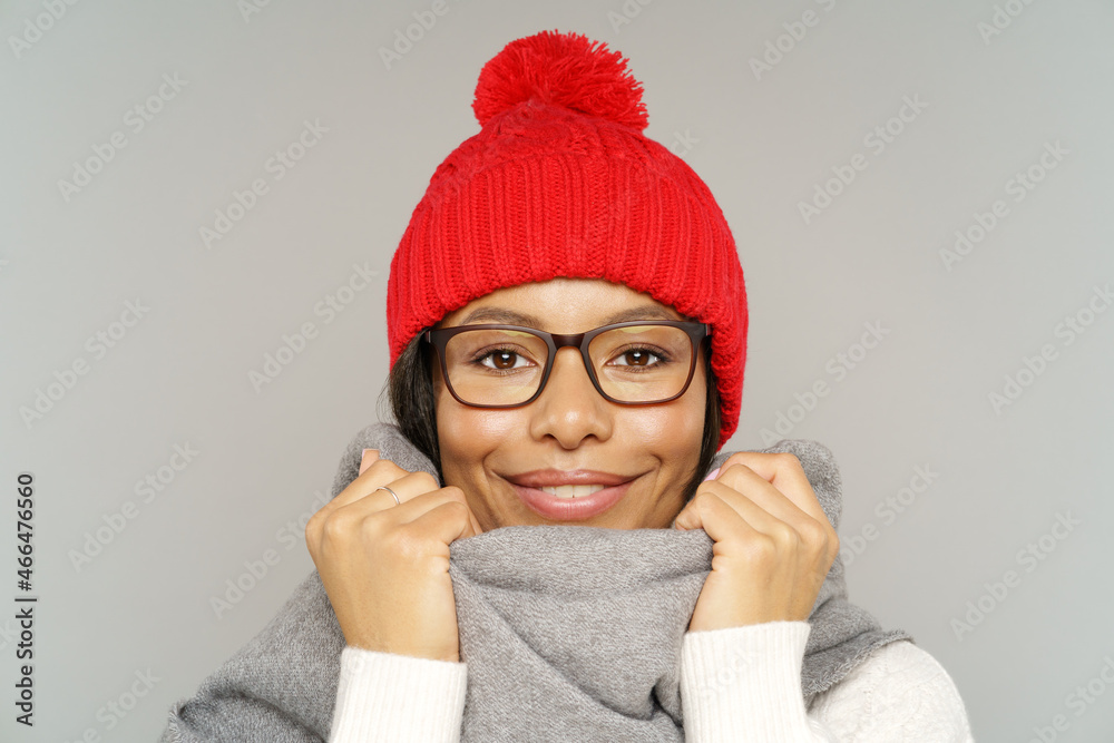 Wall mural studio portrait of cheerful african american female wearing knitted red hat and scarf preparing for 