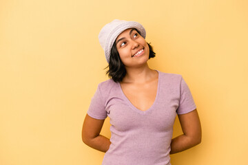 Young latin woman isolated on yellow background relaxed and happy laughing, neck stretched showing teeth.