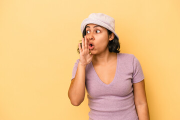 Young latin woman isolated on yellow background being shocked because of something she has seen.