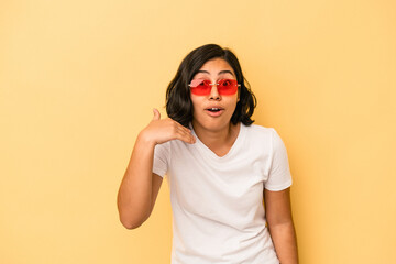 Young latin woman isolated on yellow background laughing about something, covering mouth with hands.