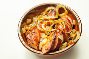 Traditionally roasted German sausage with onion served in a ceramic bowl