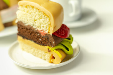 Piece of the Burger Cake, Madeira and chocolate sponge layered cake, filled with frosting covered with soft icing and edible sugar decorations