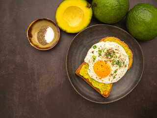 Toast with avocado and eggs served on a plate. Top view. Space for text