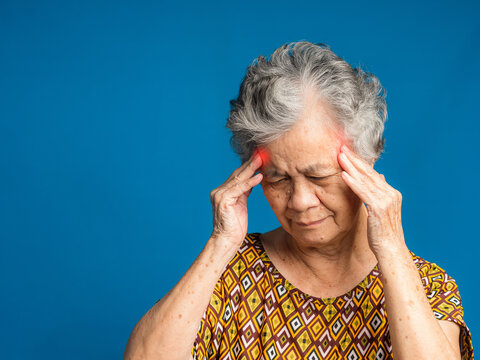 An elderly Asian woman who has a severe headache suffers from a stroke, brain attack, or migraines. Brain diseases problem cause chronic severe headaches. Aged people and healthcare concept