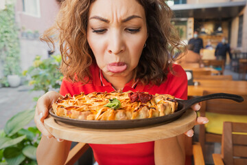 A frustrated woman in a restaurant does not feel the smell and taste of food because of the long...