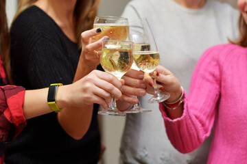 Celebration concept.People hands toasting with champagne glasses at delicious feast outdoors in the evening. Family and friends clinking glasses and cheering with alcohol