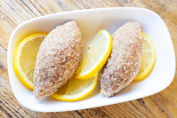 Kufta or minced turkey cutlets with lemon on a plate is a traditional dish in the Turkic and Caucasian peoples