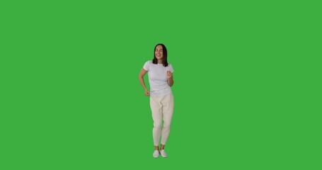 Carefree woman having fun dancing over green background - Powered by Adobe
