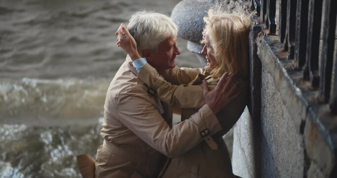 Passionate mature couple making out near city river