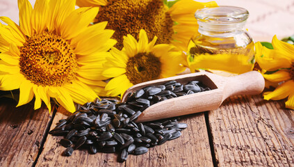 Obraz na płótnie Canvas Sunflower seeds and oil bottle on old wooden background. Selective focus.