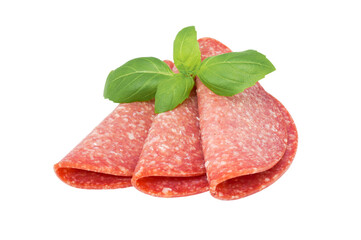 Basil on sliced salami isolated on white background with clipping path. Sausage top view.