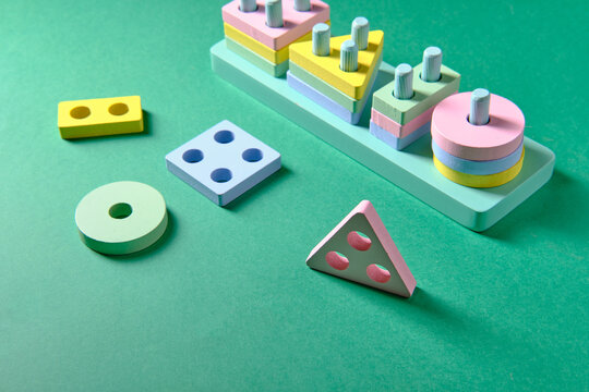 Educational toys for children in the form of different geometric shapes, on a green background