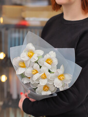 Young woman florist holding big beautiful blossoming mono bouquet of blue tulips flowers