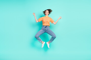 Fototapeta na wymiar Photo of charming peaceful young woman dressed striped t-shirt smiling jumping practicing yoga isolated teal color background