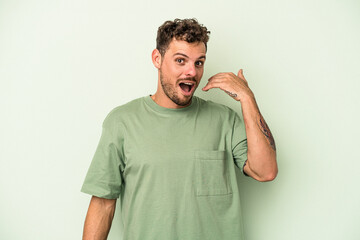 Fototapeta premium Young caucasian man isolated on green background laughing about something, covering mouth with hands.