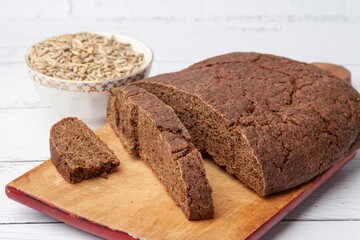 Rye bread with seeds lies on a light table. Seeds and crumbs
