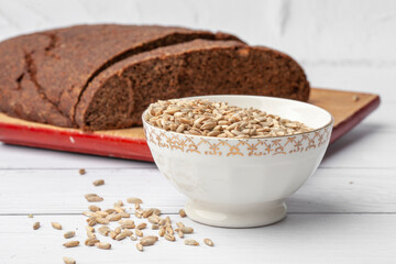 Rye bread with seeds lies on a light table. Seeds and crumbs
