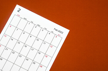 February 2022 calendar sheet on red background.