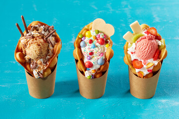 Closeup shot of bubble waffle ice cream in paper packages on a blue background