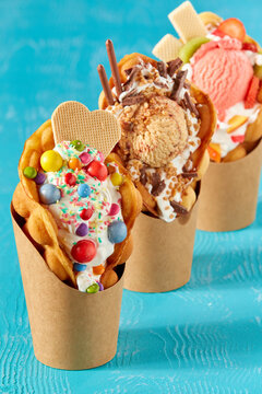 Closeup shot of bubble waffle ice cream in paper packages on a blue background