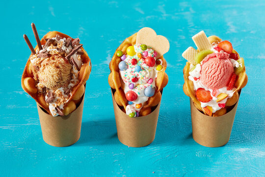 Closeup shot of bubble waffle ice cream in paper packages on a blue background