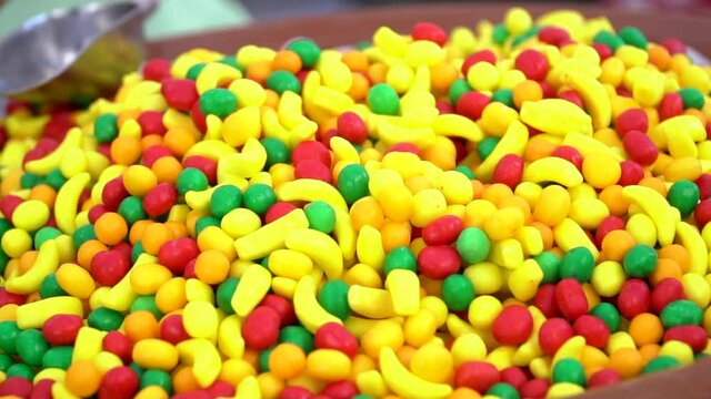 Unhealthy yellow, red and green candies in bulk. Colorful sweets candies for sale on the market. A pile of jelly candies on the market. 