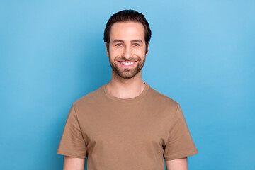 Photo of handsome pretty young guy dressed casual brown clothes smiling isolated blue color background