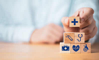 Doctor putting healthcares icon which print screen on stacking wooden cube for health medical...
