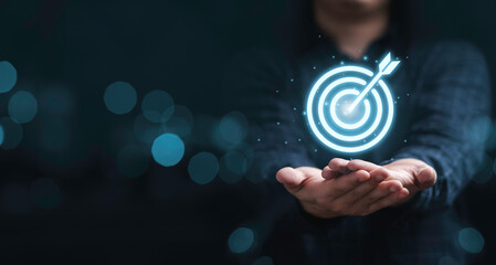 Virtual target board on hand with blue bokeh background for set up business objective target...