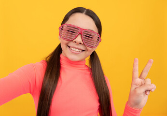 teen girl having fun. cheerful child in glasses. peace gesture. making selfie. positive emotions.