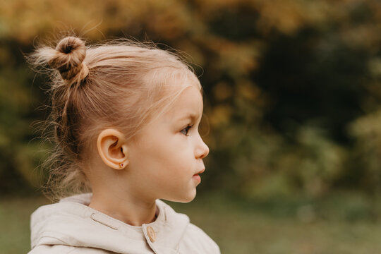 Autumnal mood. Portrait of a little cute girl walking in the autumn park. Profile photo