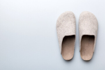 Warm winter women woolen slippers on colored background. Copy space for text